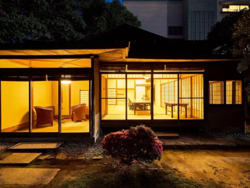 Exterior of Suisui Garden Ryokan, a traditional Japanese building nestled in a forest.