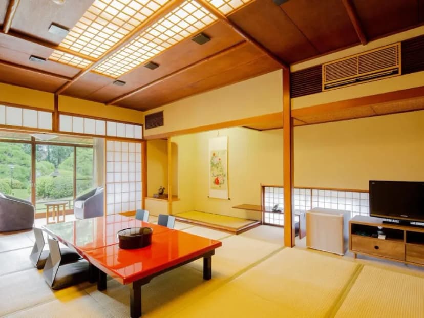 Interior of a ryokan room with tatami mat floors and minimalist wooden furniture.